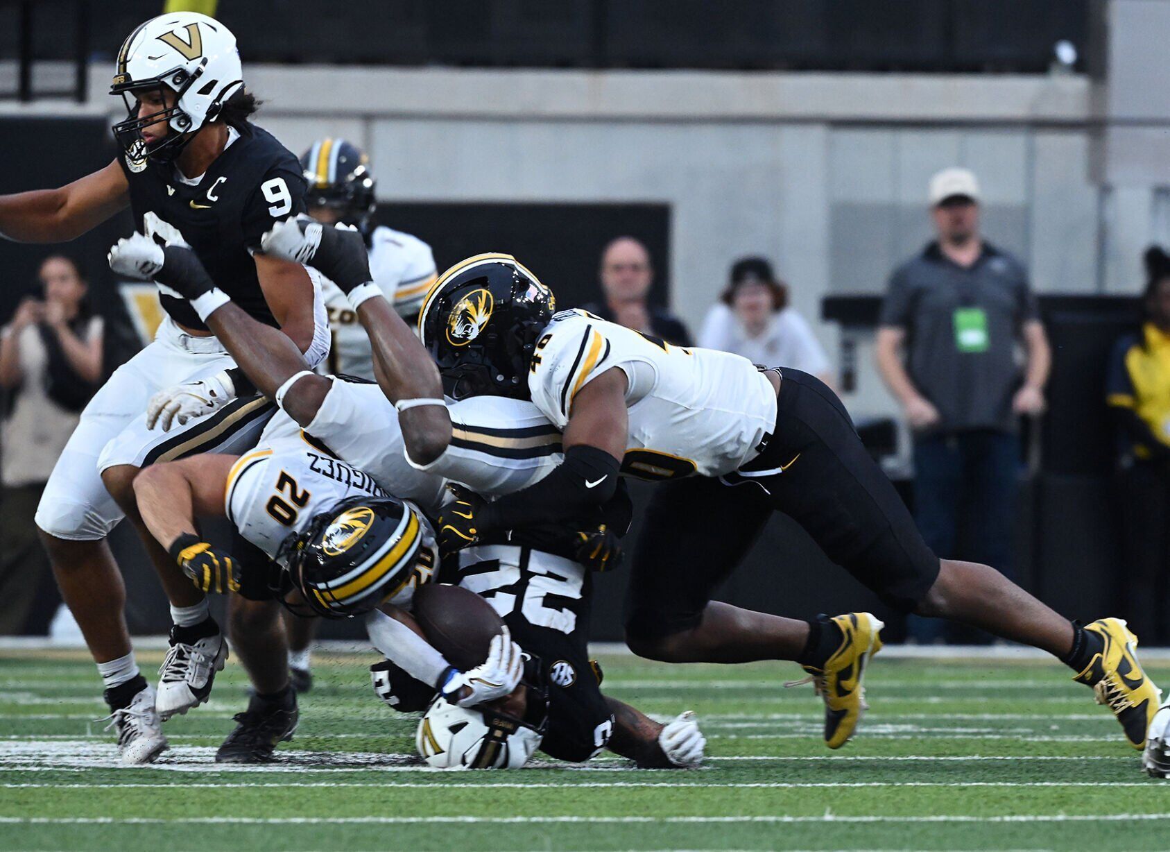Missouri linebacker Nicholas Rodriguez (20) and Missouri linebacker Josiah Trotter (40) bring down Vanderbilt running back Makhilyn Young (22)